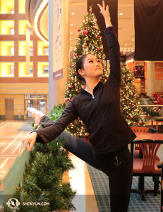 Penari utama Shen Yun Touring Company, Xindi Cai melakukan pemanasan di lobi Pusat Seni Aronoff di Cincinnati, Ohio yang berhiaskan pohon natal. (Foto oleh penari Helen Li)