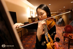 Pemain biola Karen Chen dalam persiapan terfokus. Artis seperti Chen - bahkan walau ia menutup 100 pertunjukan tahun ini sendiri dan dengan 11 musim Shen Yun yang sudah diikuti - ia selalu berusaha untuk lebih menyempurnakan seni nya. (Foto oleh Annie Li)