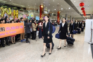 Penari Utama Elsie Shi diikuti oleh penari lainnya yang tiba dengan barang bawaan mereka di Taiwan. 
