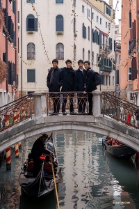 Para penari berhenti sejenak di salah satu dari 400 lebih jembatan yang menghubungkan Venice, saat sebuah gondola lewat di bawahnya.

(Foto oleh William Li)